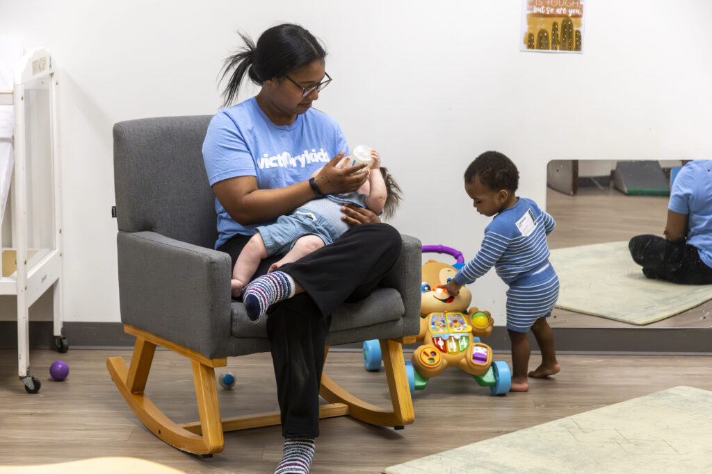 Baby being fed by volunteer at Victory Church